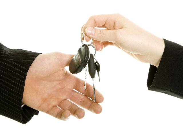 Person übergibt Autoschlüssel an eine andere Person