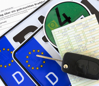 Deutsche Fahrzeugunterlagen mit Nummernschildern, Autoschlüssel, Umweltplakette und Fahrzeugschein